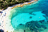 Touristen schwimmen im türkisblauen Meer am Strand von Emplisi, Blick von oben, Fiskardo, Kefalonia, Ionische Inseln, Griechische Inseln, Griechenland, Europa