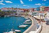 View of colourful cafes, restaurants and boats in harbour against blue sky, Cales Fonts, Menorca, Balearic Islands, Spain, Mediterranean, Europe