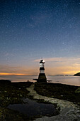 Starry night sky over Trwyn Du lighthouse (Penmon lighthouse), Penmon Point, Anglesey, North Wales, United Kingdom, Europe
