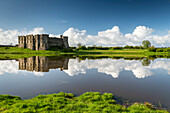 The magnificent ruins of Carew Castle reflected in the Mill Pond in spring, Carew, Pembrokeshire, Wales, United Kingdom, Europe