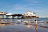 Spaziergänger am Strand von Eastbourne Pier bei Sonnenuntergang, Eastbourne, East Sussex, England, Vereinigtes Königreich, Europa