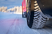 Winter tyre of car driving on slippery road in the snowy forest, Kangos, Norrbotten County, Lapland, Sweden, Scandinavia, Europe