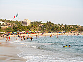 Playa Principal, der relativ ruhige Strand am kleinen Hafen von Puerto Escondido, ein beliebter Ort zum Schwimmen und Essen von Meeresfrüchten, Oaxaca, Mexiko, Nordamerika