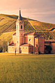Kirche und Glockenturm bei Sonnenuntergang mit Weinbergen in Herbstfarben im Hintergrund, Emilia Romagna, Italien, Europa