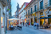 Blick auf eine belebte Straße mit Cafés und Bars in der Altstadt von Porto in der Abenddämmerung, Porto, Norte, Portugal, Europa