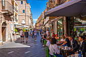 Blick auf Cafés und Restaurants an einer belebten Straße in Taormina, Taormina, Sizilien, Italien, Mittelmeer, Europa