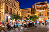 View of cafes and restaurants on busy street in Taormina at dusk, Taormina, Sicily, Italy, Mediterranean, Europe