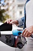 Woman charging electric car