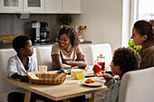 Mothers and sons eating breakfast