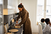 Frau wäscht Geschirr zu Hause
