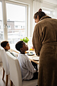 Mother and sons having breakfast at home