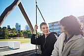 Friends sitting on swing