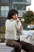 Teenage girl playing with pinwheel outdoors