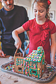 Vater und Tochter zerstören ein Lebkuchenhaus