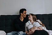 Pregnant woman with partner in bed