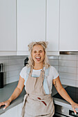 Woman in kitchen sticking her tongue out