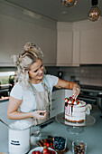 Woman in kitchen decorating cake