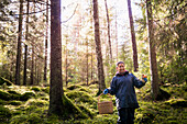 Frau beim Pilzesammeln im Wald