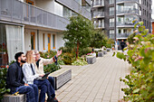 Men and woman with laptop looking at buildings