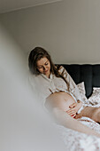 Pregnant woman sitting in bed