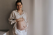 Pregnant woman holding hands on belly