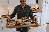 Woman carrying tray with food