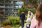 Men with baby stroller walking in residential area