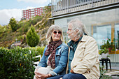 Lächelndes älteres Ehepaar sitzt im Freien