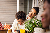 Mother and son sitting at table outdoors