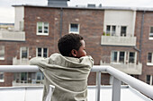 Rückansicht eines Jungen, der auf einem Balkon steht