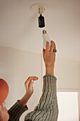 Woman changing light bulb