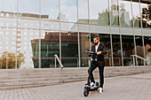 Businessman riding scooter