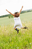 Young woman jumping in field