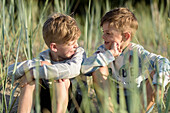 Smiling boys sitting in grass