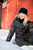 Young woman sitting in snow