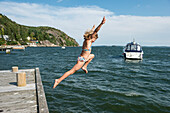 Woman jumping into sea