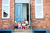 Children sitting on steps and eating apples