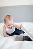 Babyjunge schaut auf Laptop