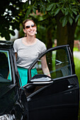 Woman standing by black car