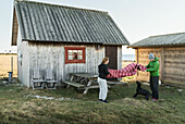 Couple with dog in front of wooden house