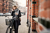 Junge Frau mit Fahrrad, die telefoniert