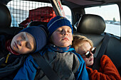 Kinder schlafen auf der Rückbank eines Autos