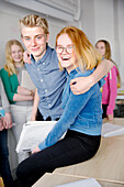 Teenager umarmen sich im Klassenzimmer