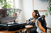 Woman with headphones listening to records