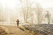 Frau joggt an einem nebligen Morgen
