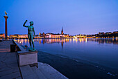 Männliche Statue am Meer. Das Rathaus von Stockholm im Hintergrund, Schweden