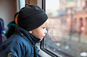 Boy looking through train window