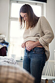 Pregnant woman getting dressed