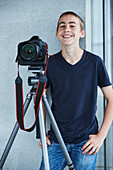 Digital camera in front of smiling teenage boy