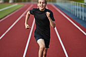Teenage boy running in sports track